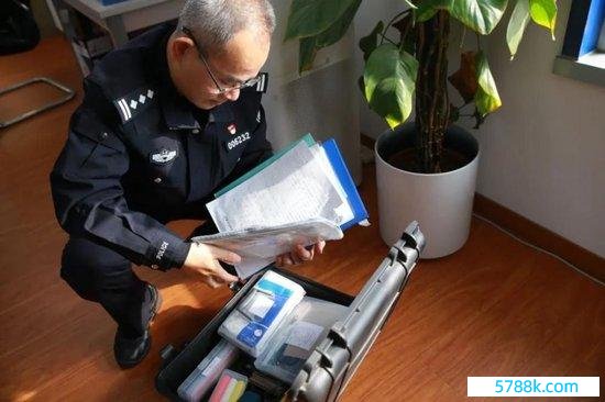 张雷向记者展示出警时佩戴的器用箱。侯欣颖/摄